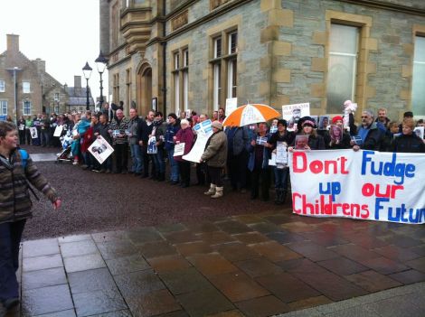 Parents link arms around Lerwick Town Hall to protest against council cuts on 13 November. Photo Shetnews