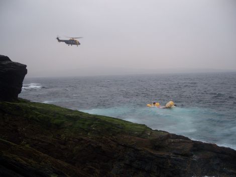 A Jigsaw search and rescue helicopter flies over the Super Puma crash site - Photo: Peter Hutchison/ShetNews