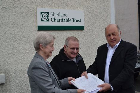 Charitable trust chairman Bobby Hunter receiving the petition from Sandy MacMillan and his wife Gail. Photo: Daniel Lawson