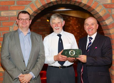 Former Shetland Recreational Trust chairman Joe Irvine (centre) receives a clock from general manager James Johnston this week, with new chairman Bryan Leask. Photo SRT