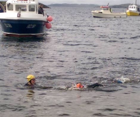 Surrounded by small boats two of the swimmers on their way to Whalsay - Photo: Jeni Polson