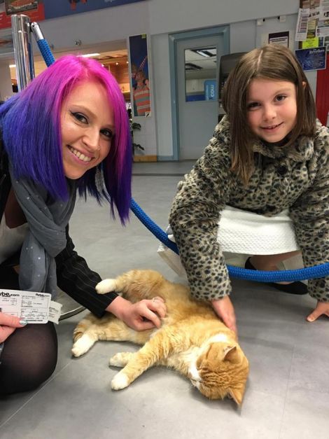 Katrina Williamson and her daughter Layla getting acquainted with Tigger while waiting for a flight.