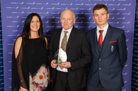 Paul Woods (centre) receives the impact club of the year award from Team GB track and field athlete Derek Hawkins, accompanied by Julie Mollison, Scottish Athletics National Club manager (north). Photo: Bobby Gavin.