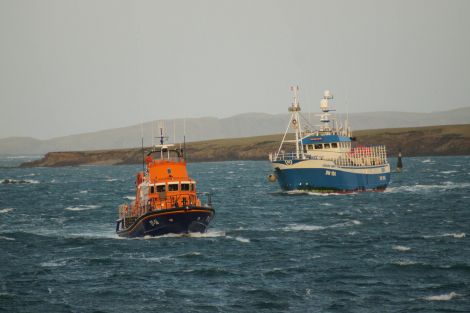 Crab boat Edward Henry heading back to the safety of the port alongside the Aith lifeboat. Photo: Leslie Tulloch