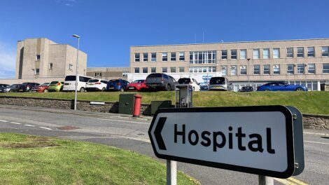 A hospital sign in front of a building.