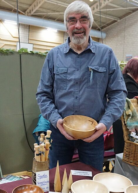 A man standing in front of a table full of bowls.