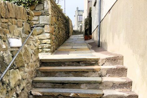 A stone stairway leading up to a stone wall.