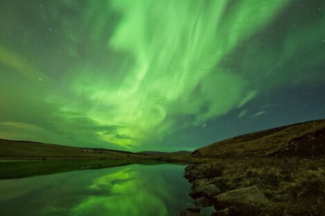 An aurora bore over a pond in iceland.