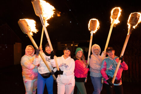 A group of women holding fire torches.