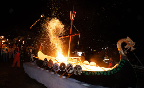 A viking boat with fire on it.