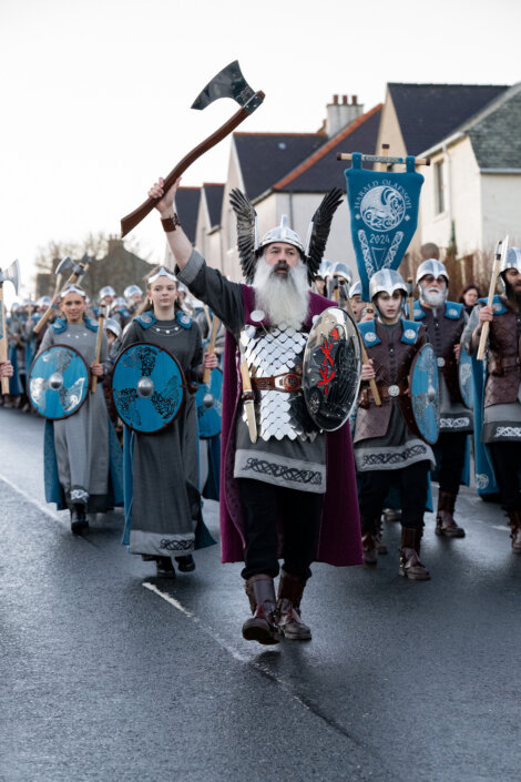 A group of vikings marching down a street.