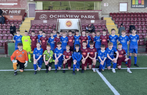 Youth football teams posing together at ochilview park stadium.